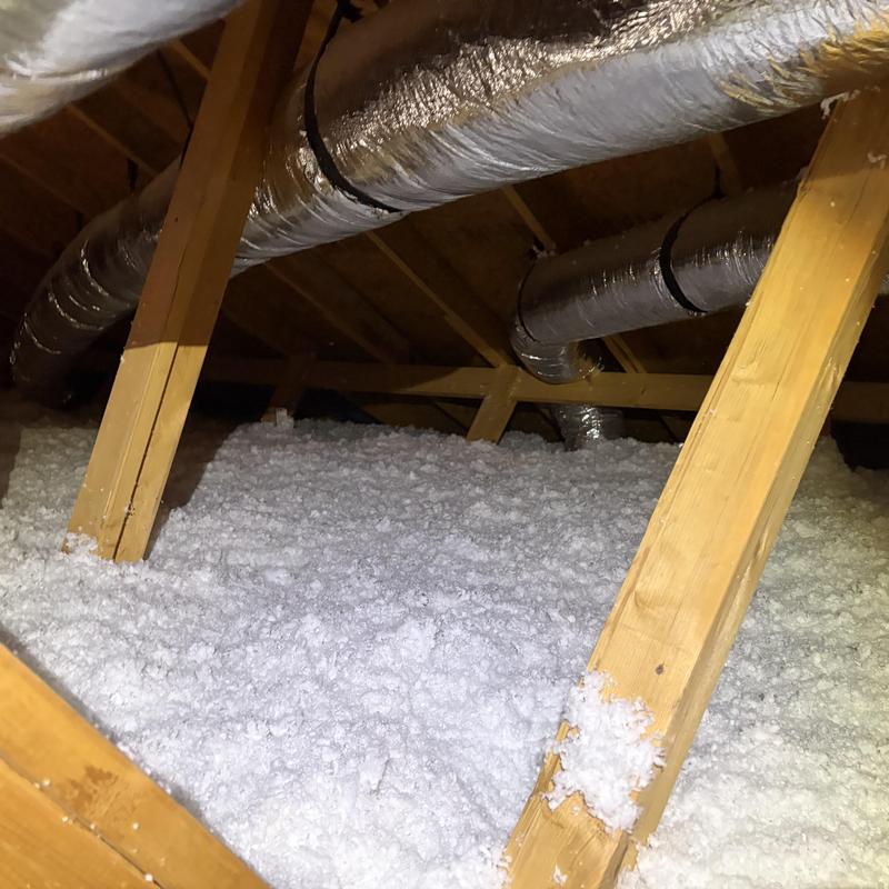 Attic insulation with ductwork in wooden frame attic