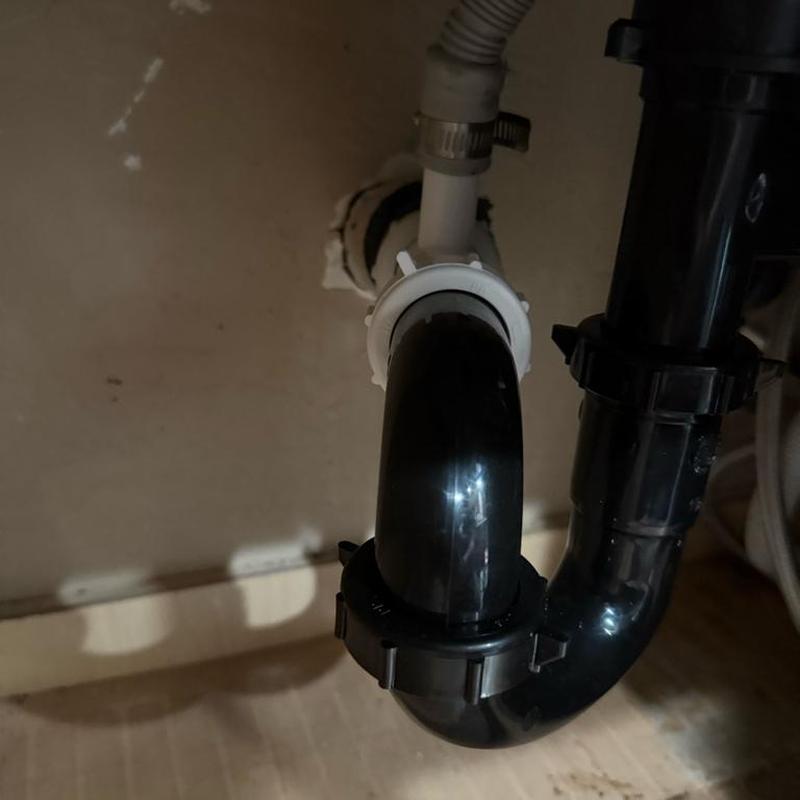 Black sink drain trap installation with white coupling