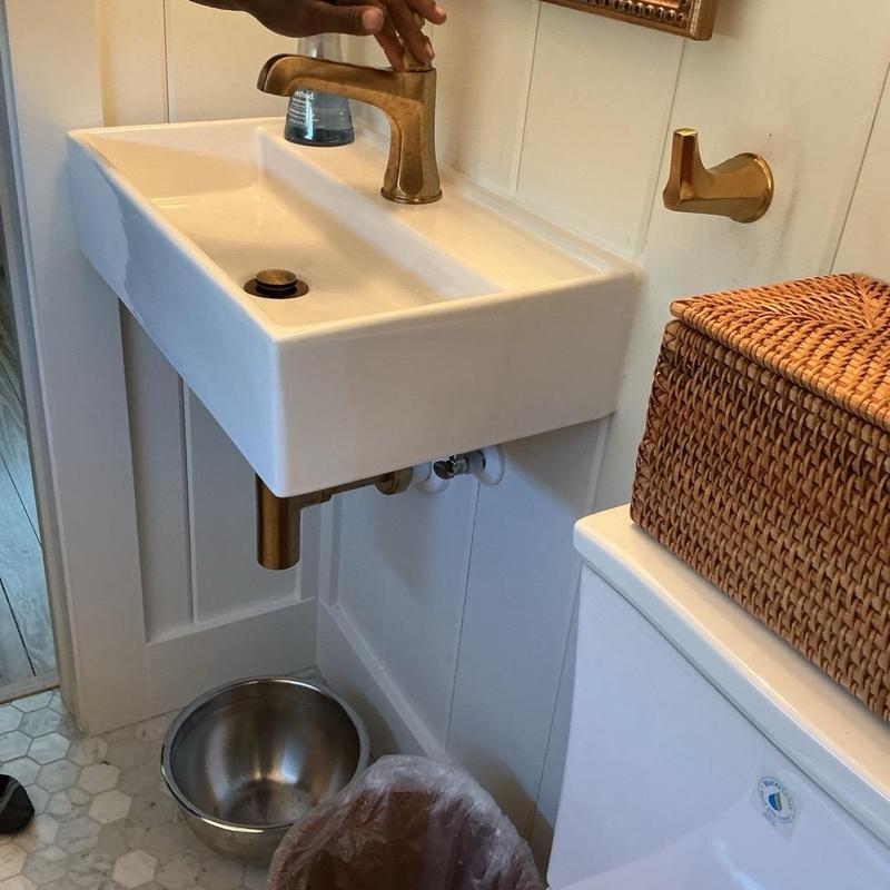 Bathroom sink faucet with gold finish being adjusted Bathroom sink faucet with gold finish being adjusted