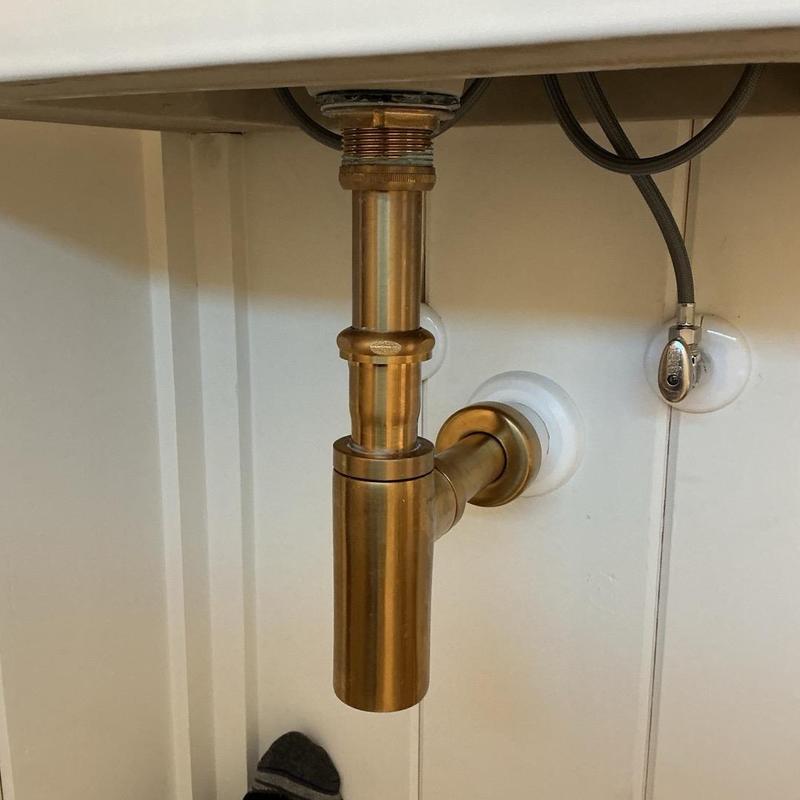 Brass sink drain pipe and gasket tightened under sink Brass sink drain pipe and gasket tightened under sink