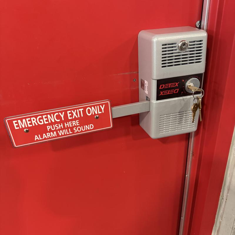 Detex alarmed emergency exit push bar on red door Detex alarmed emergency exit push bar on red door