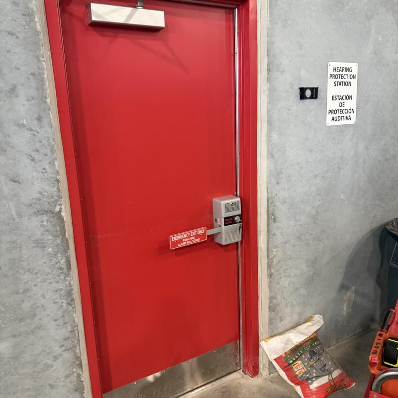 Detex alarmed exit device on red emergency door Detex alarmed exit device on red emergency door