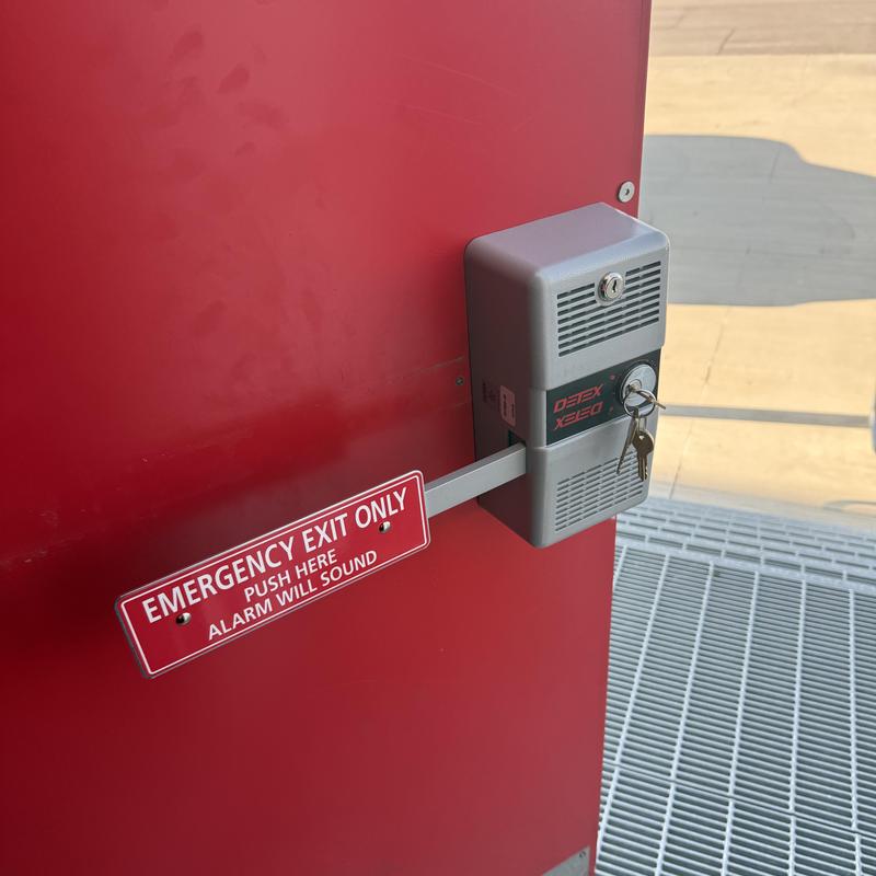 Detex alarmed push bar on emergency exit door Detex alarmed push bar on emergency exit door
