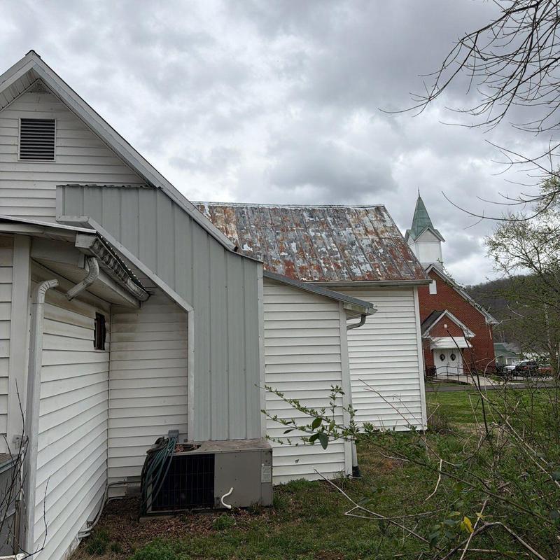 Rusty metal roof with weathered shingles in Normandy, TN