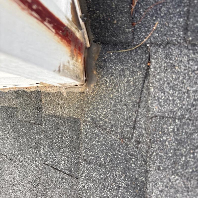 Roofing shingles and flashing with rust on wall edge