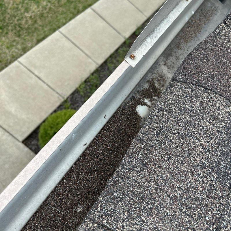 Asphalt shingle roof and aluminum gutter edge close-up