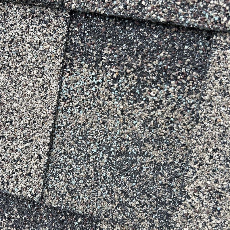 Roof shingles with granular hail damage close-up