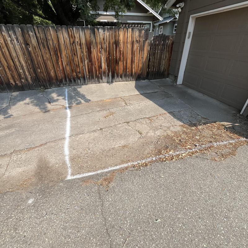 Clay sewer line excavation area marked on driveway
