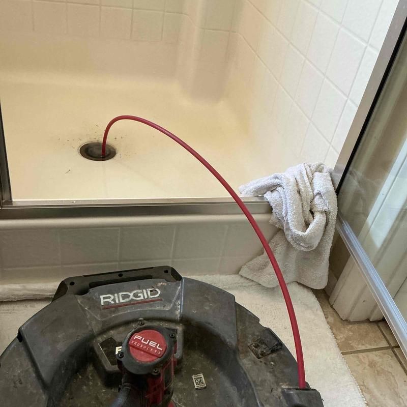 Shower drain with rigid flex shaft clog removal tool