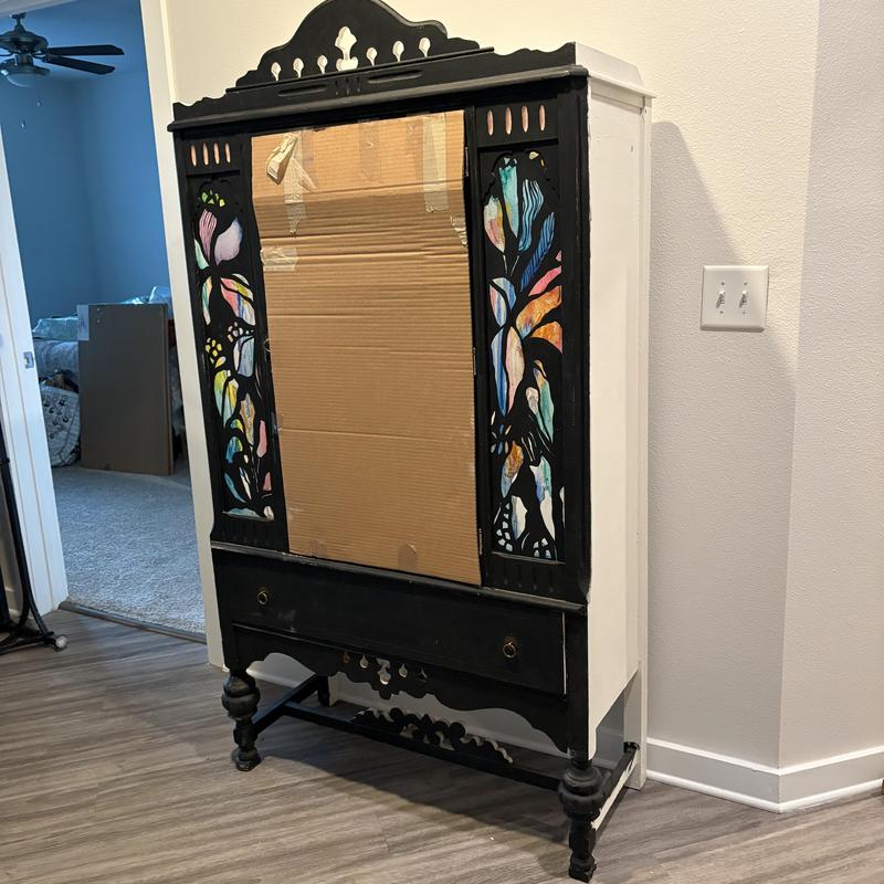 Antique wooden cabinet with painted glass panels