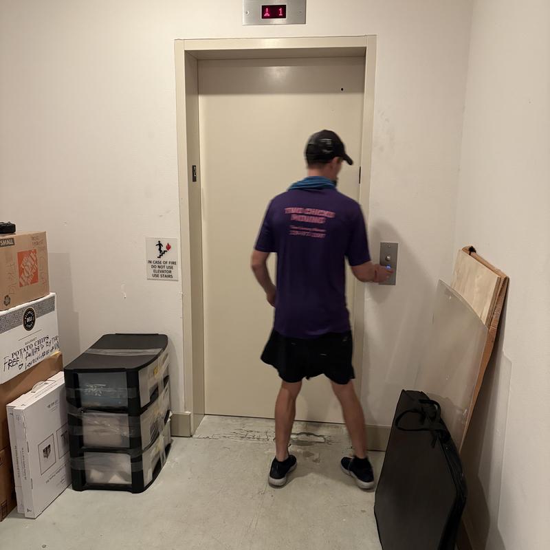 Elevator door with moving pod and worker in hallway