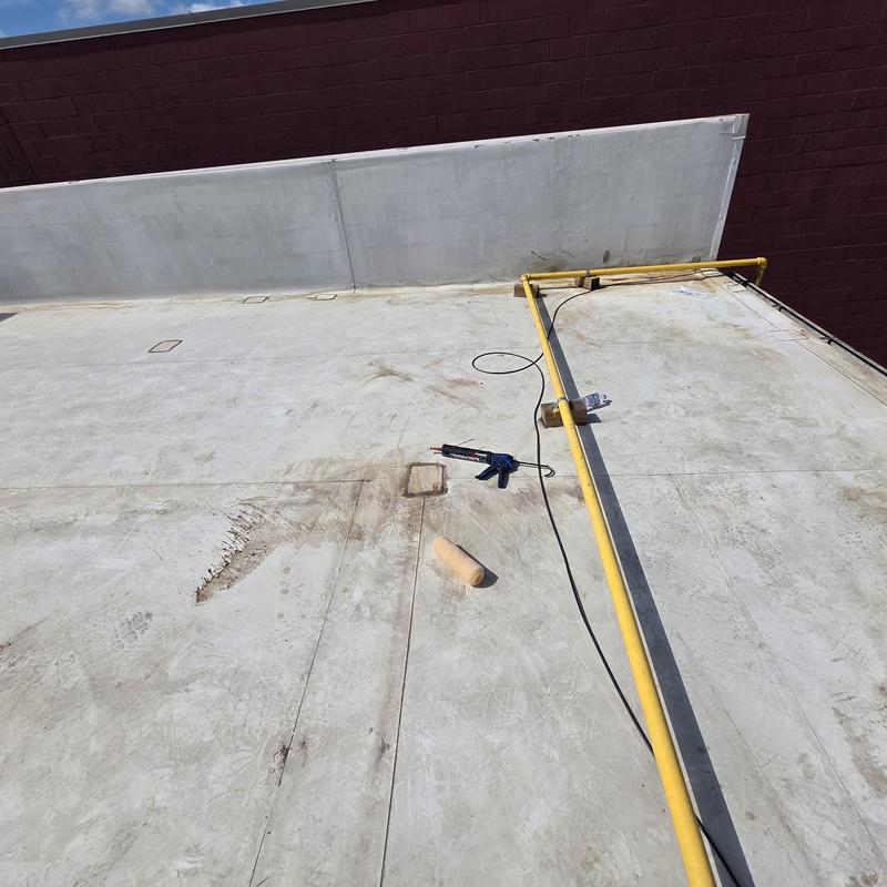 Silicone roof restoration tools on flat commercial roof