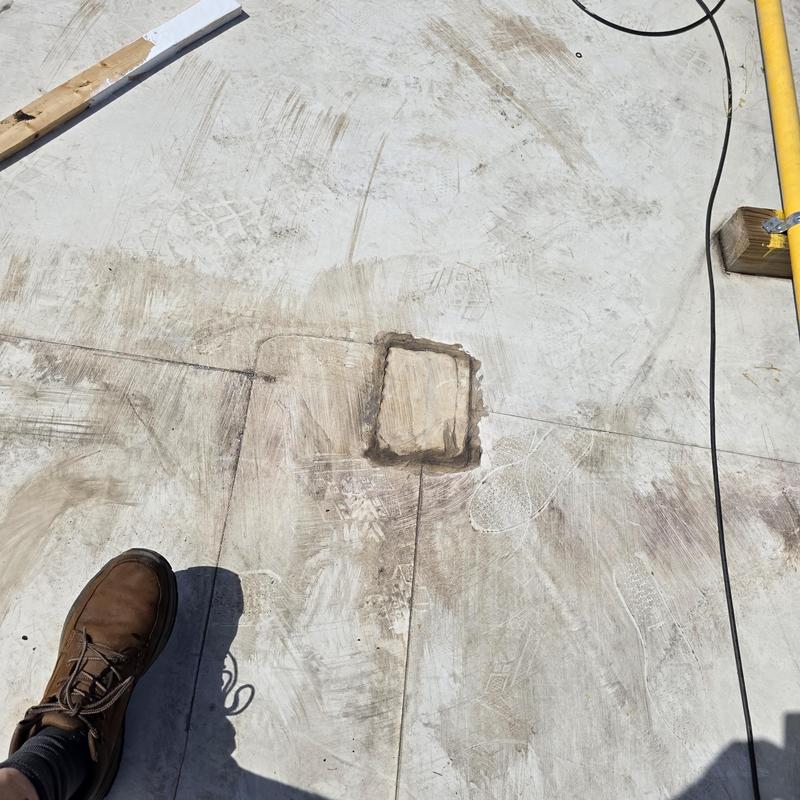 Silicone roof restoration patch on flat roof surface