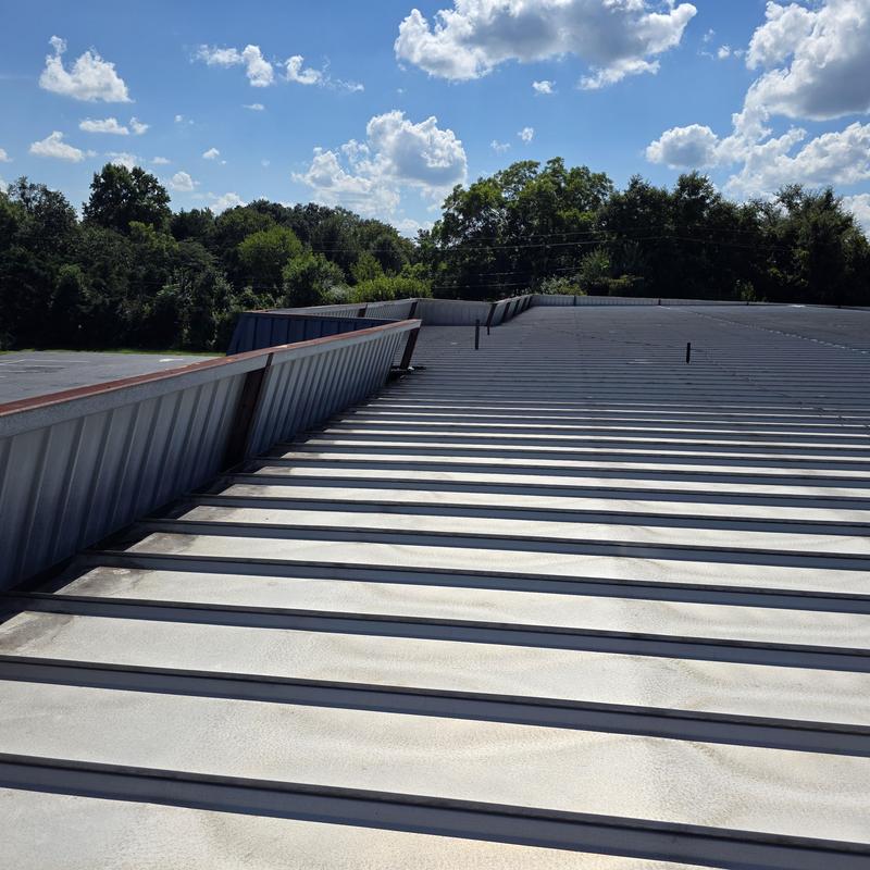 Metal roof panels on commercial building under clear sky