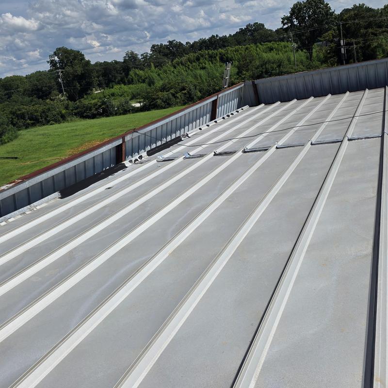 Metal standing seam roof with repaired damage panels