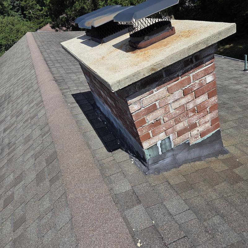 Brick chimney with flashing on asphalt shingle roof Brick chimney with flashing on asphalt shingle roof