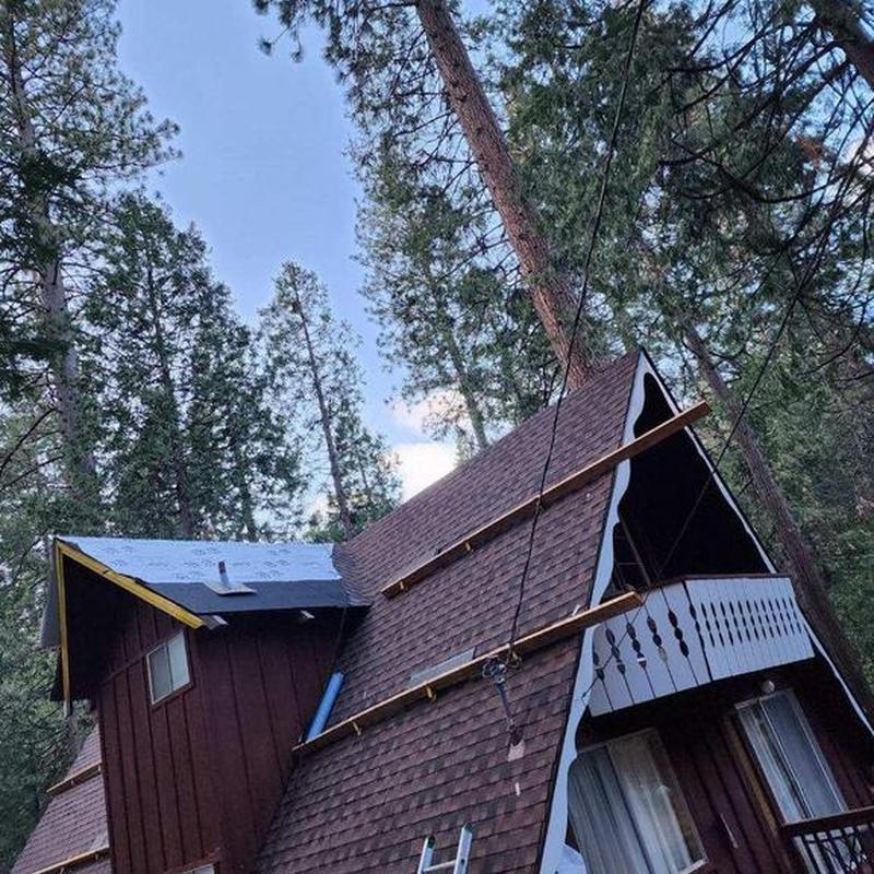 Roof shingles installation on A-frame cabin roof