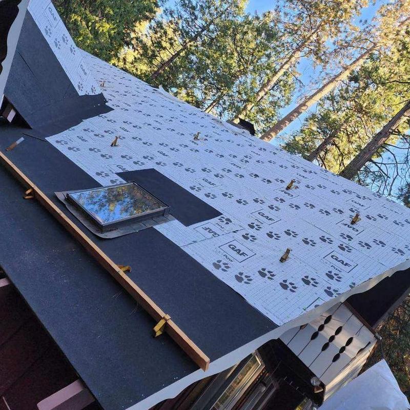 Roof underlayment installation with skylight in forest area