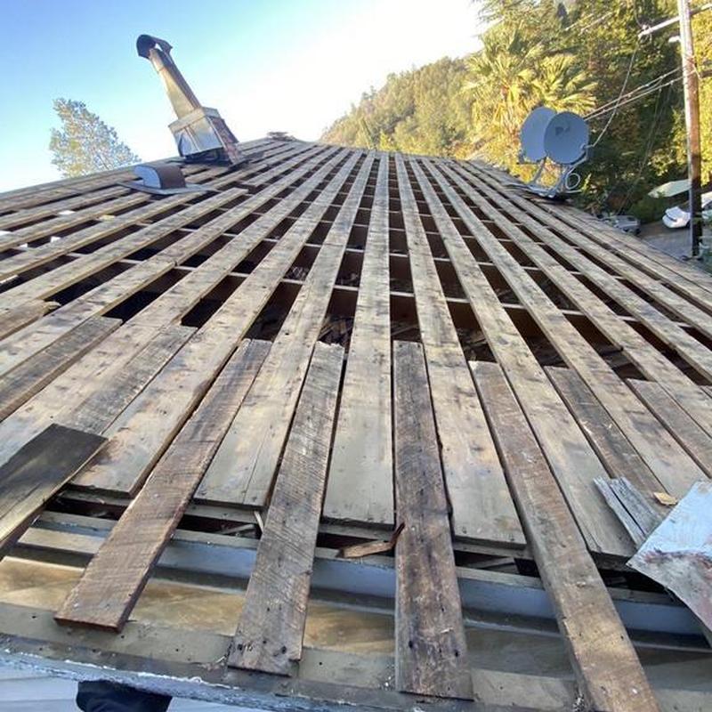 Wood roof decking with dry rot damage on house roof