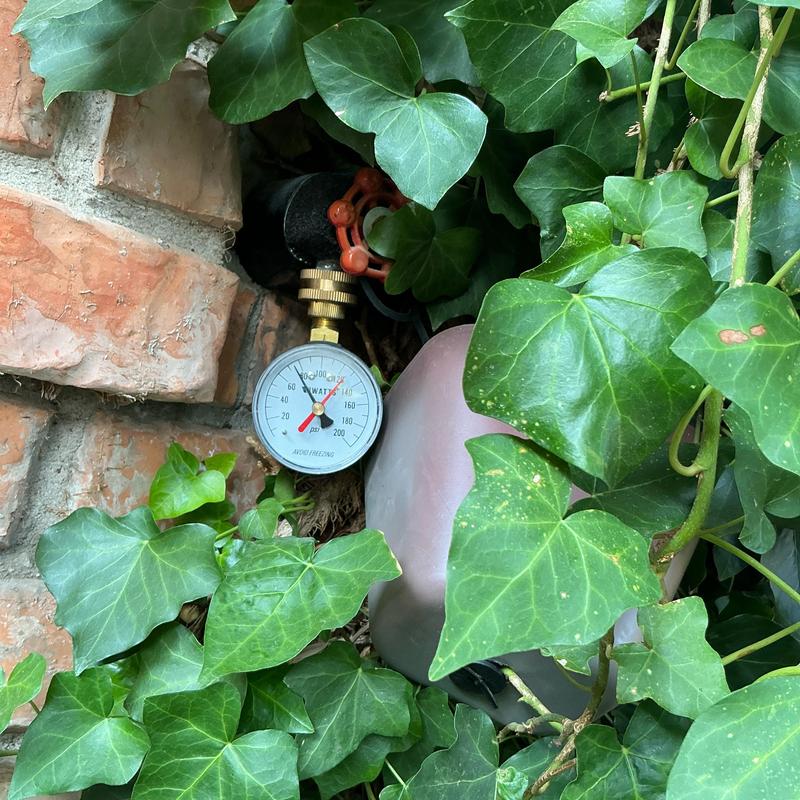 Hose bib pressure gauge installed among leaves