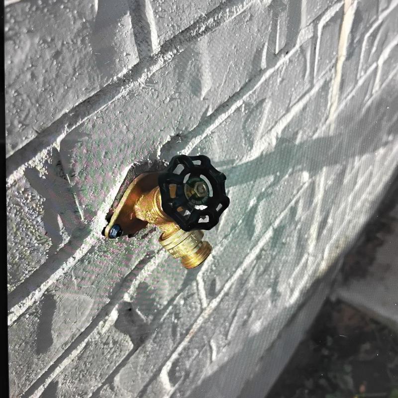 Hose bib with new brass fittings on exterior wall