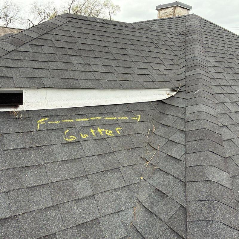 Roof shingles and gutter area with damaged flashing