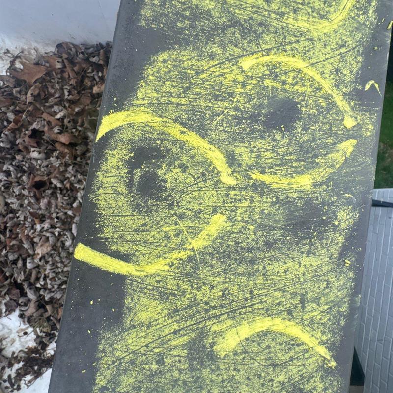 Metal roof panel hail damage marked with yellow chalk