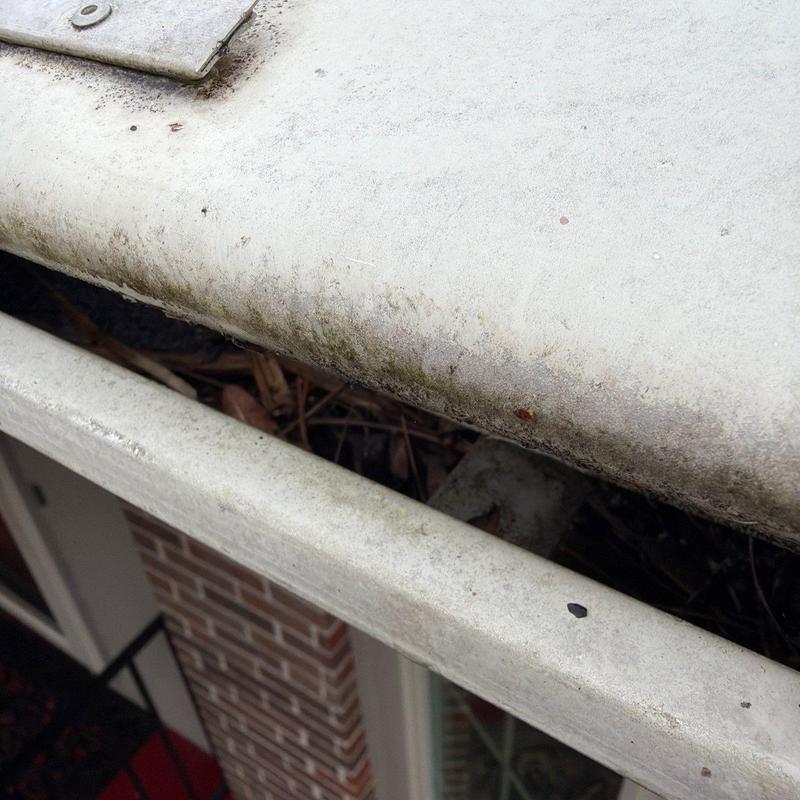Gutter system with debris buildup on roof edge