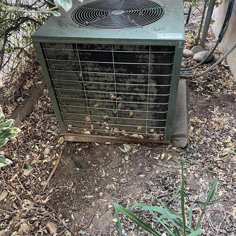 1980s outdoor HVAC condenser unit with debris buildup 1980s outdoor HVAC condenser unit with debris buildup