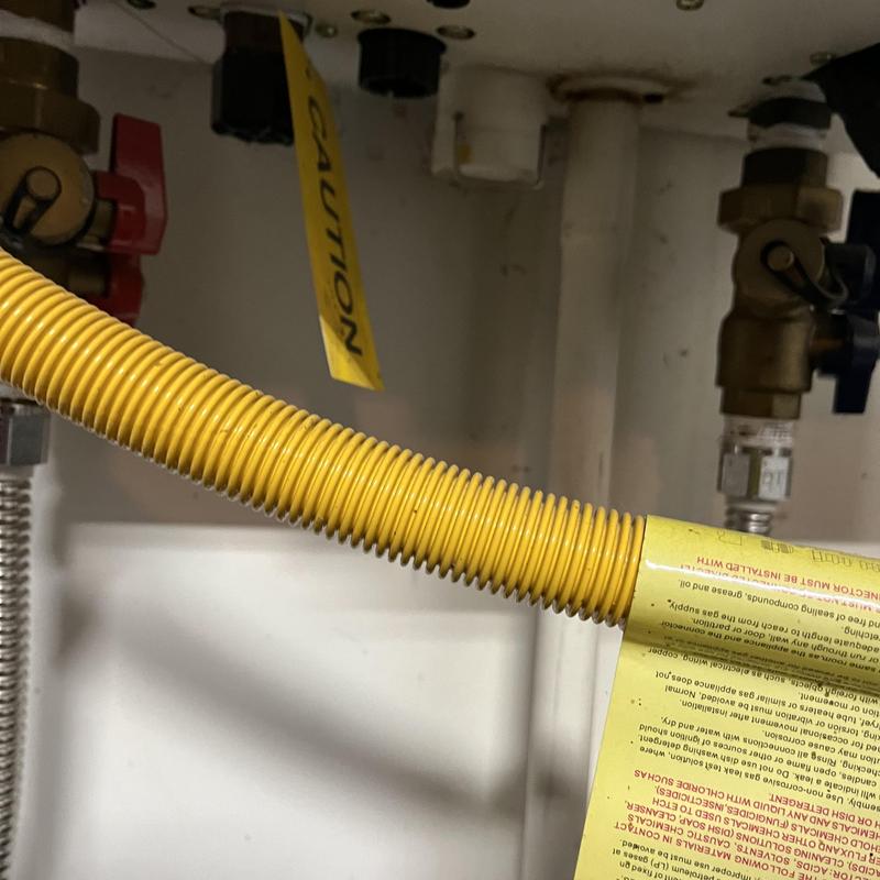 Tankless water heater gas line with caution label Tankless water heater gas line with caution label