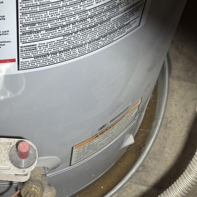 Water heater tank with warning labels and piping Water heater tank with warning labels and piping