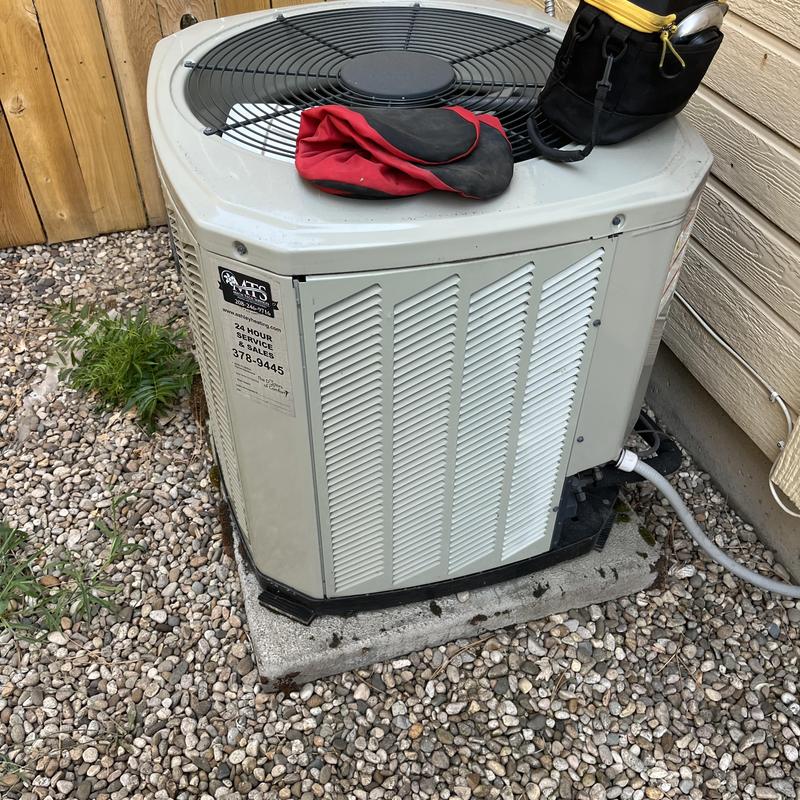 Outdoor HVAC unit with tools on top in gravel area Outdoor HVAC unit with tools on top in gravel area