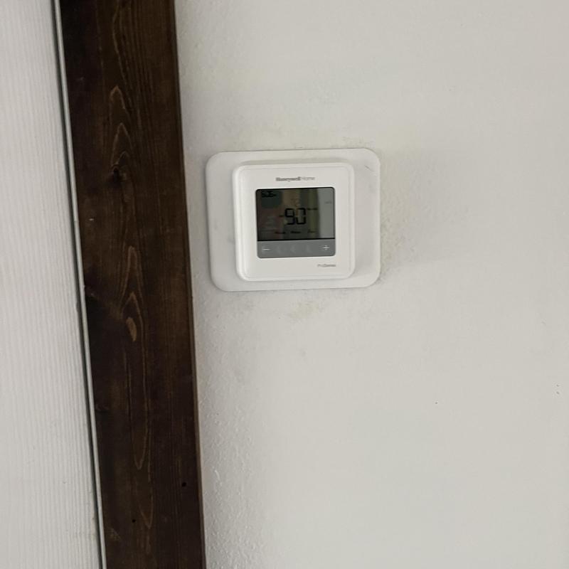 Honeywell thermostat on wall set to 90 degrees Honeywell thermostat on wall set to 90 degrees