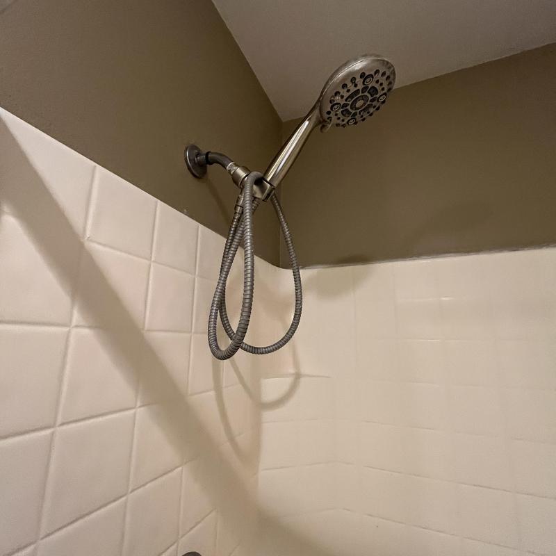 Showerhead and hose in tiled shower corner Showerhead and hose in tiled shower corner