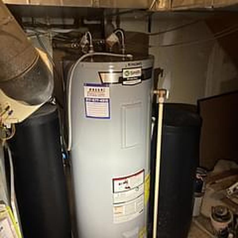 Water heater tank with connected plumbing in basement Water heater tank with connected plumbing in basement