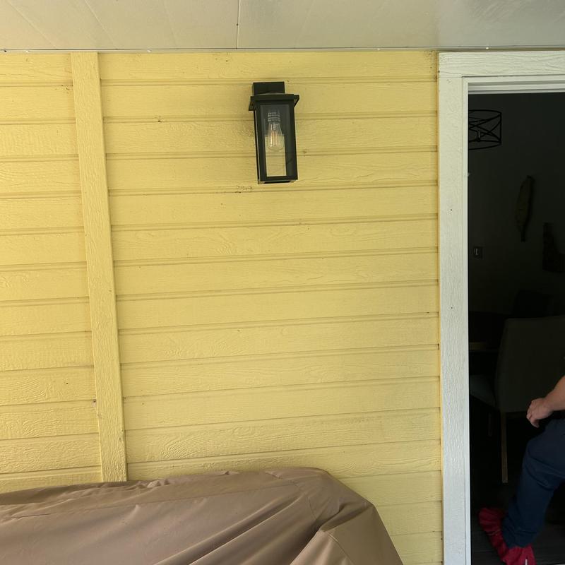 Exterior light fixture on yellow siding near door