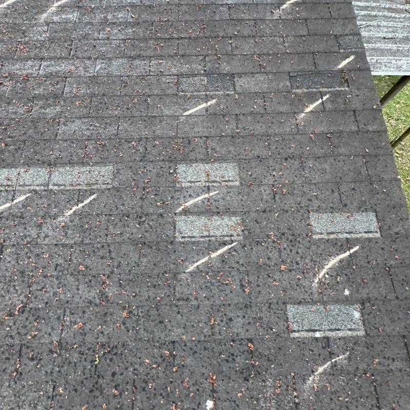Asphalt roof shingles marked for hail damage inspection