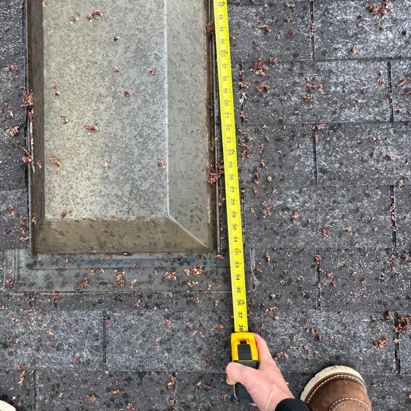 Roof flashing with hail damage and measuring tape