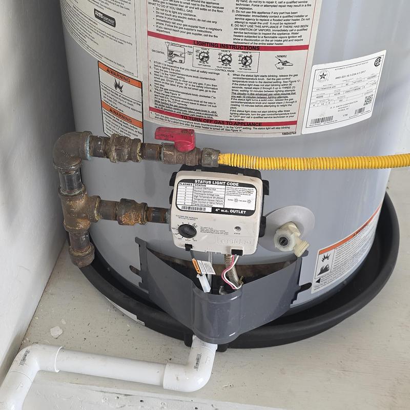 Gas control valve on water heater with gas line and pipes