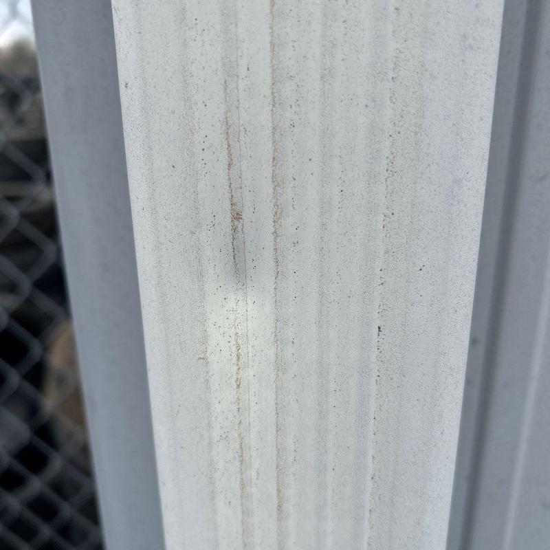 Metal roofing panel with hail damage stains