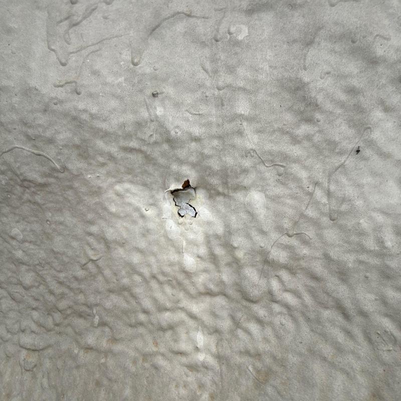 Commercial roofing hail damage with puncture hole