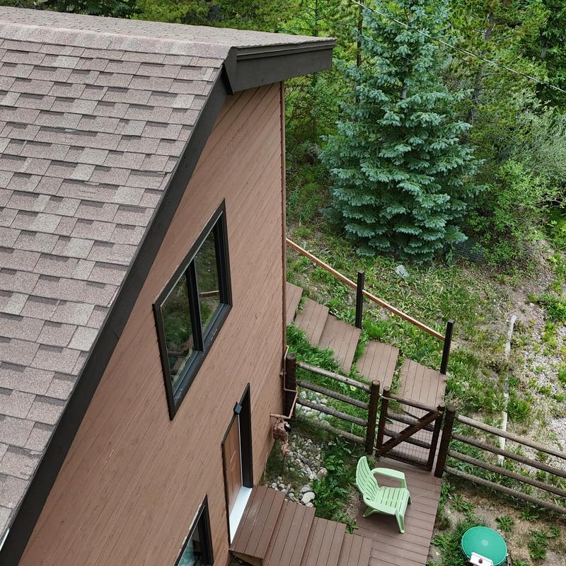 Asphalt shingle roof with wood siding and deck stairs