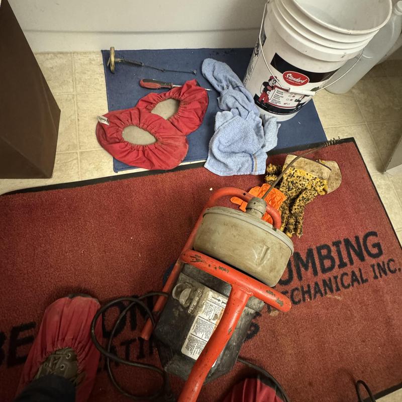 Sewer drain auger with plumber’s tools on floor