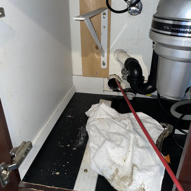 Kitchen sink drain line with cleaning rod and grease buildup
