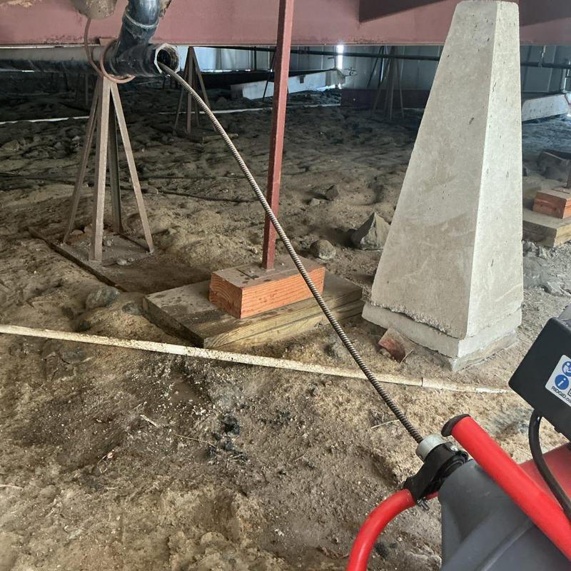 Main drain line snake cleaning in crawl space