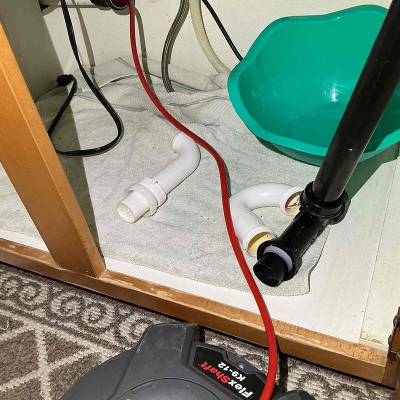 Kitchen sink drain with plumbing snake and fittings