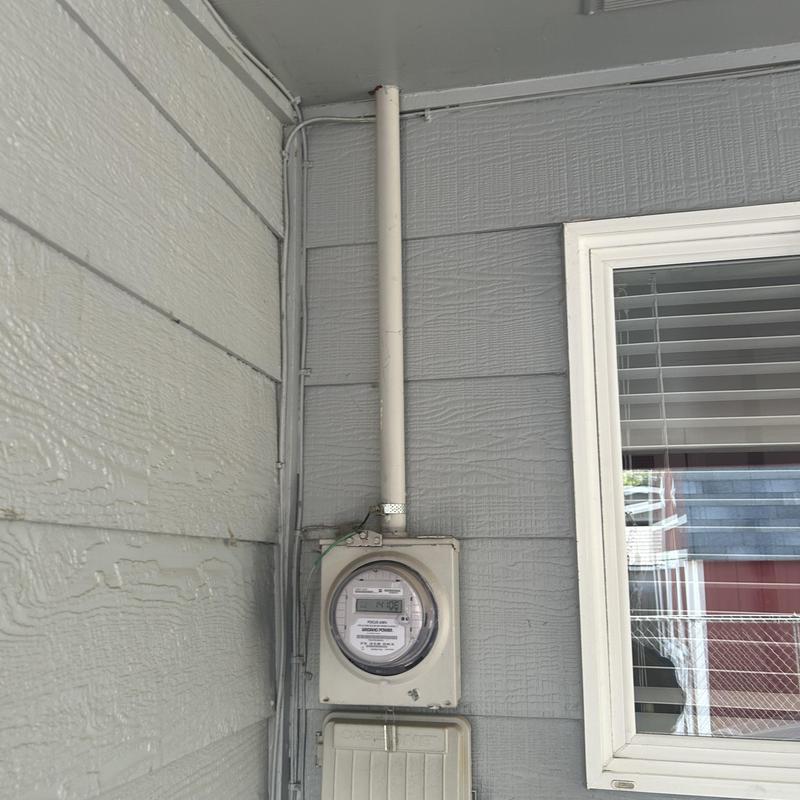 Electric meter with conduit on exterior wall Electric meter with conduit on exterior wall
