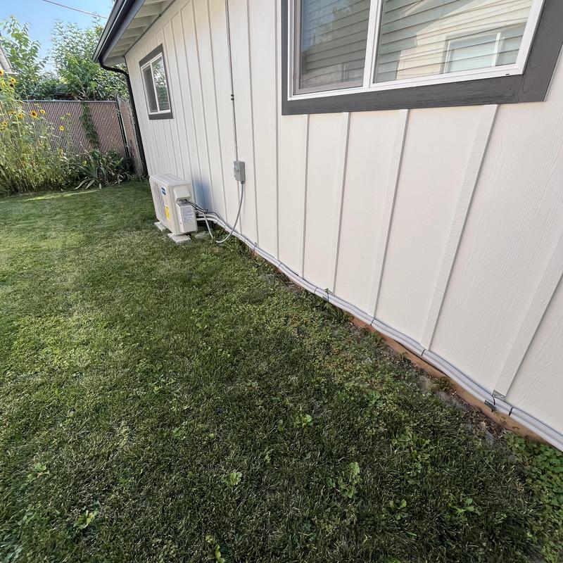 Mini split outdoor unit by house exterior wall Mini split outdoor unit by house exterior wall