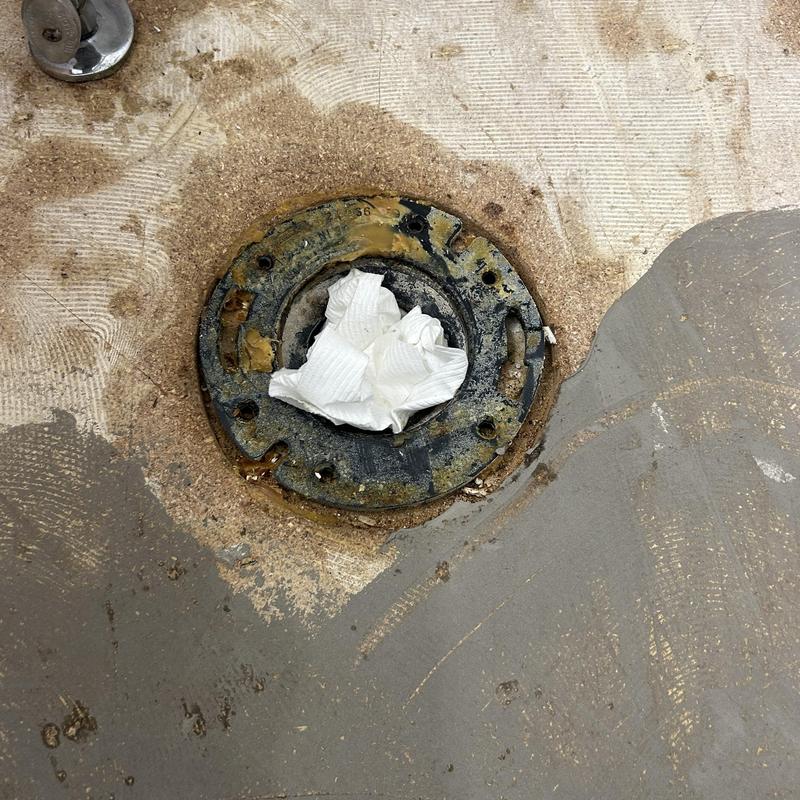 Toilet flange with paper towel blocking drain opening Toilet flange with paper towel blocking drain opening