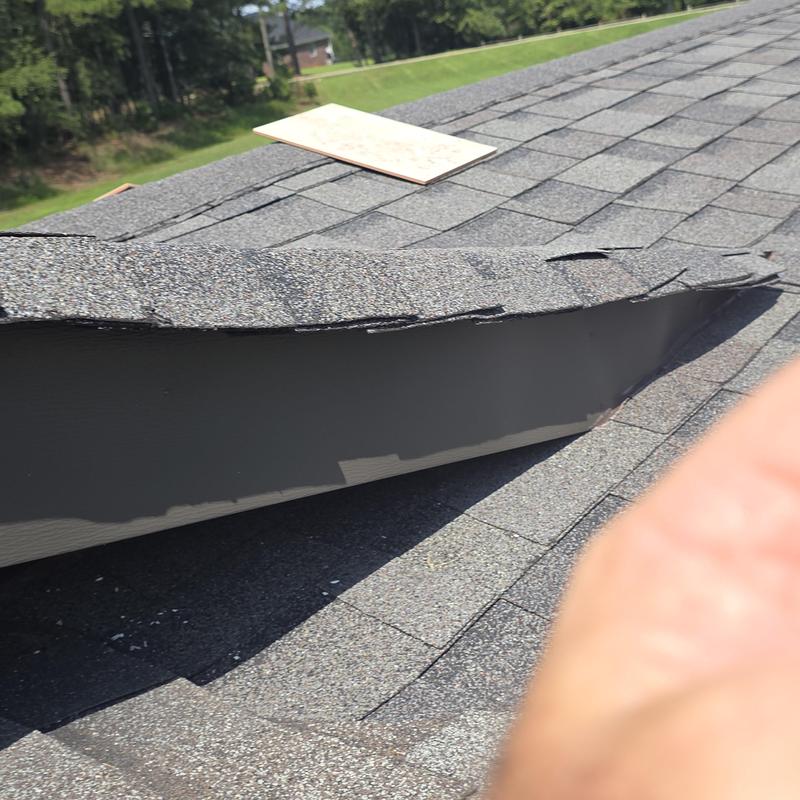 Shingle roof tie-in with lifted shingles and damage